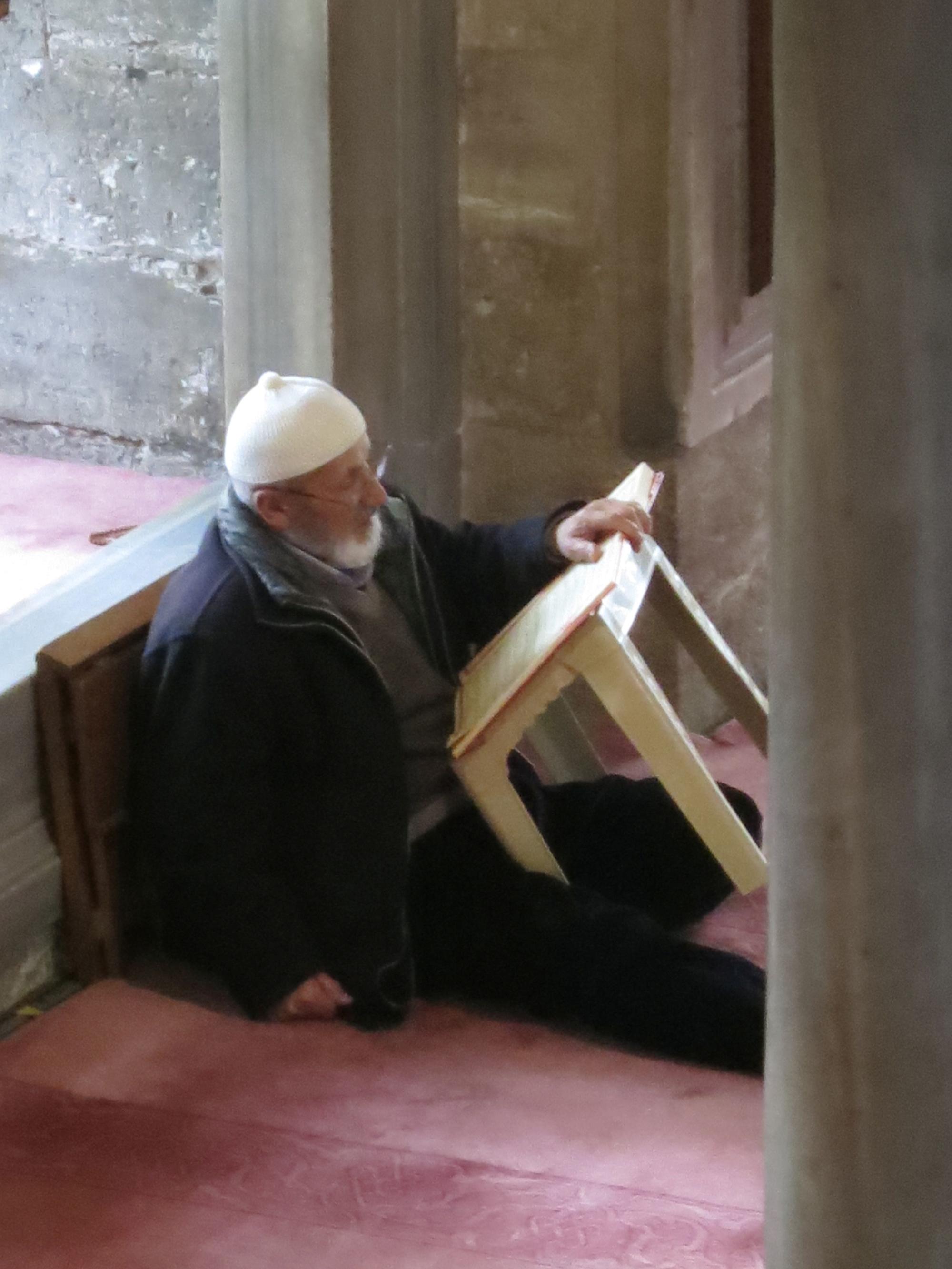 Man in a mosque sits and reads